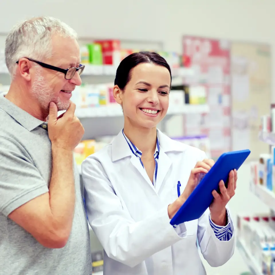 Farmacista mostra informazioni su un tablet a un cliente
