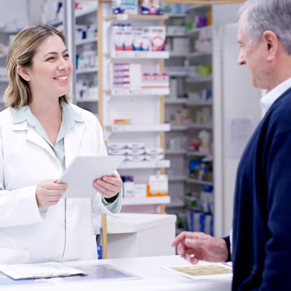 Farmacista al banco assiste un cliente in farmacia